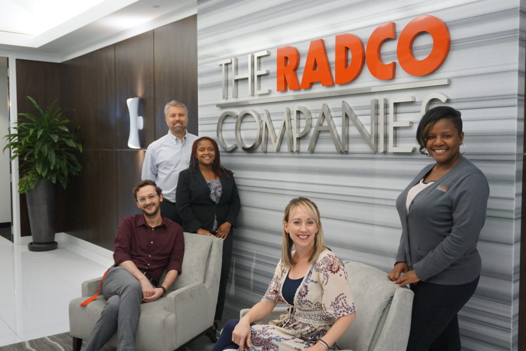 The RADCO team in front of the company sign